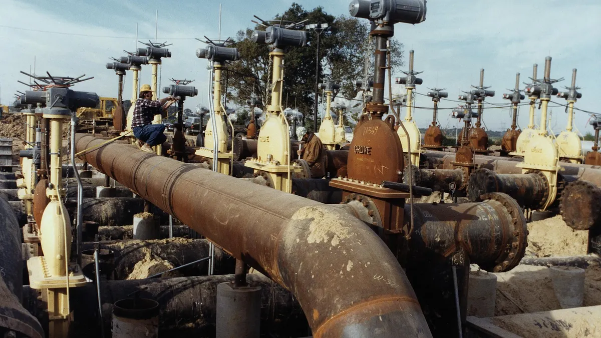 Outdoor pressure piping run with instrument heads and a field technician