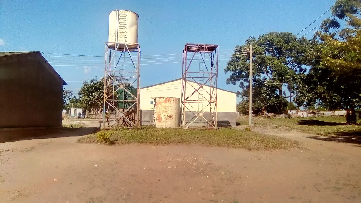 White cylindrical water tank raised on a steel lattice stand