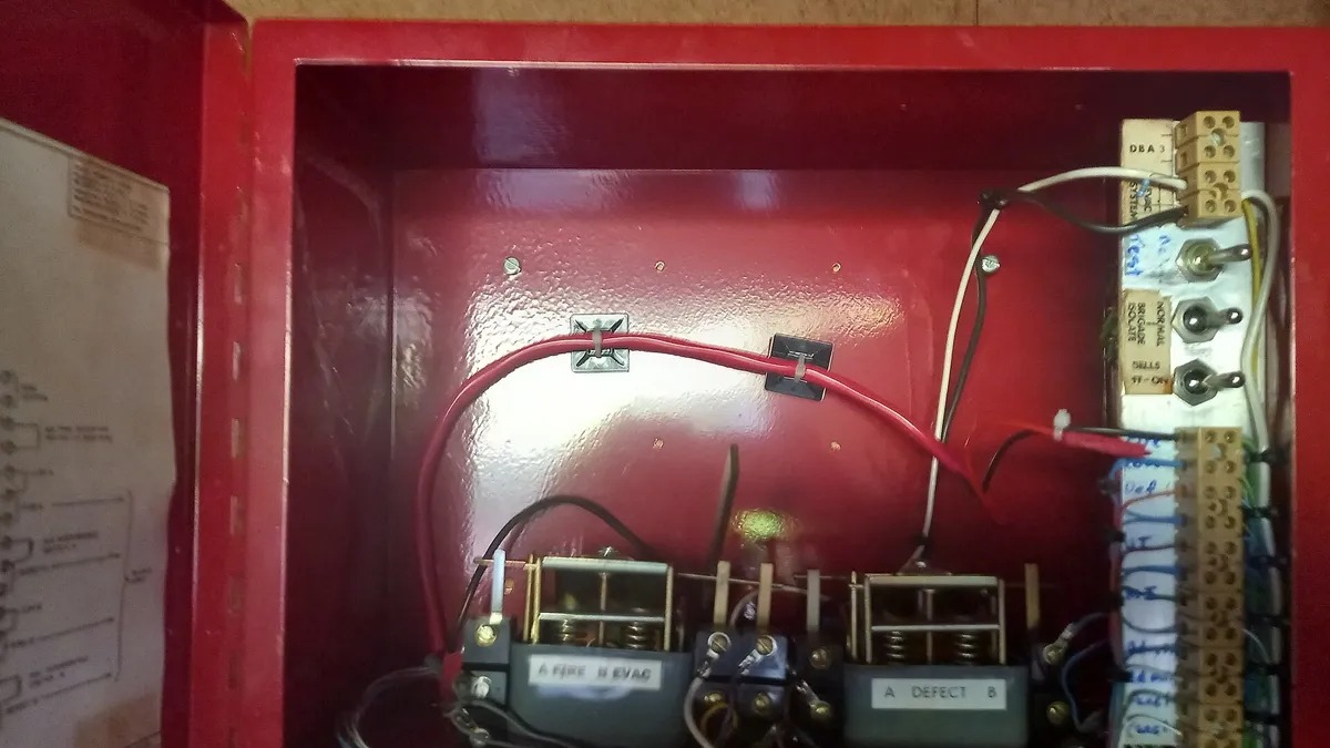 Terminal blocks and wiring inside a red electrical control enclosure