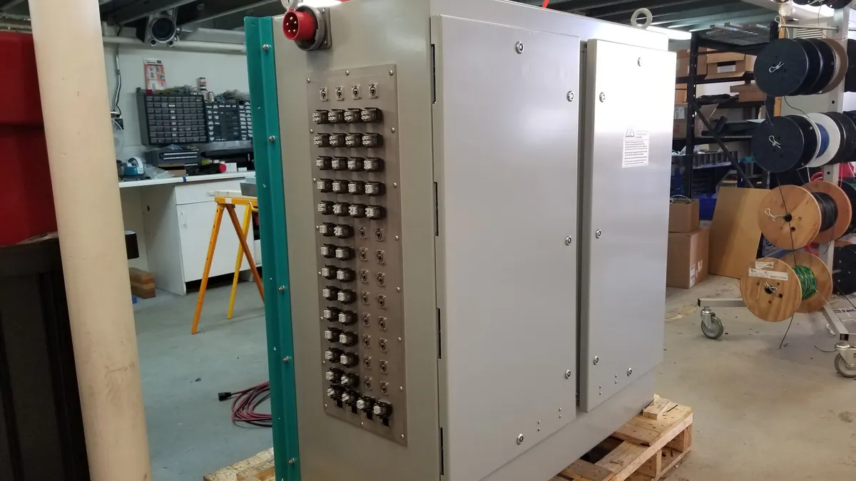 Grey electrical control cabinet staged on a wooden pallet