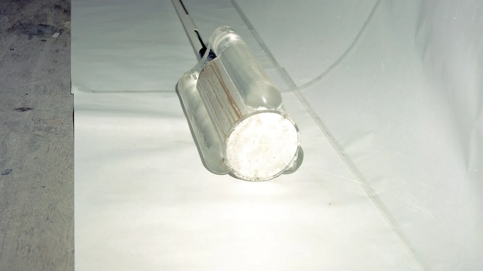 Polished cylindrical sensor suspended on a wire inside a test enclosure