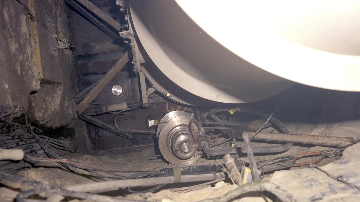 Round analog gauge among cabling in an industrial corner