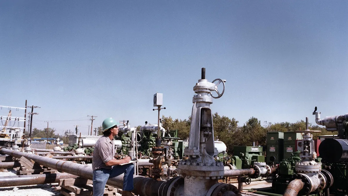 Field worker inspecting pipeline valves at a process site